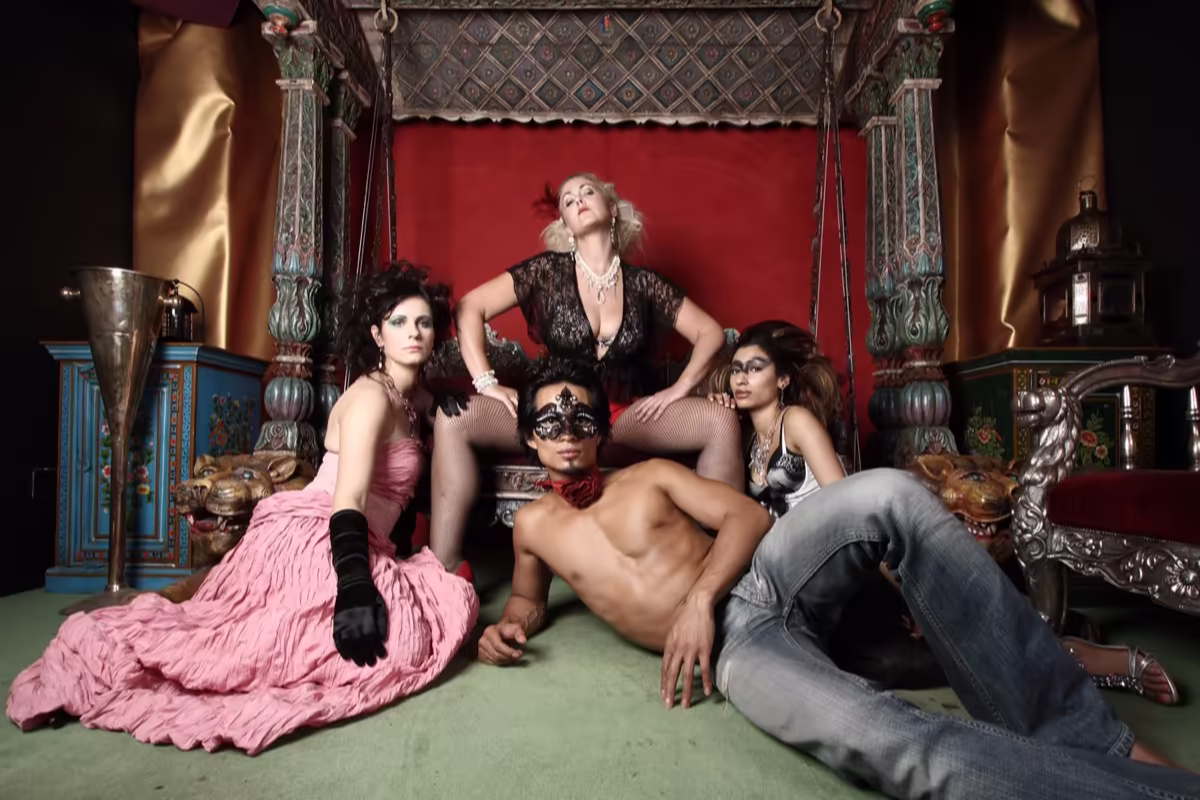 Four people posing together in an ornate, stylish setting